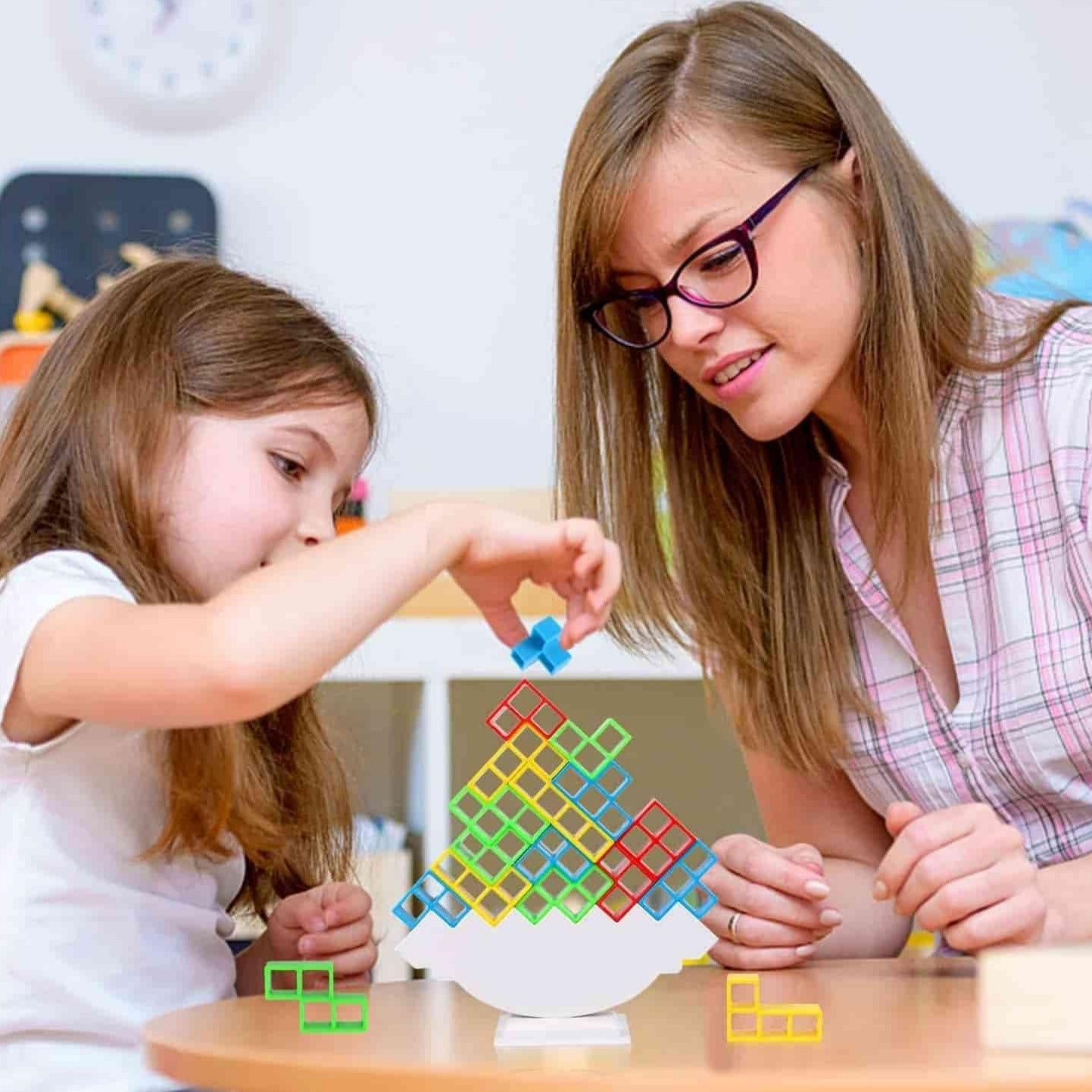 Woman and child playing with colorful puzzle toys at a table.